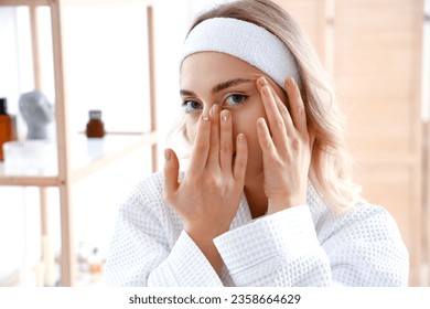 Young woman doing face building exercise in bathroom, closeup - Powered by Shutterstock