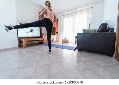 Young Woman Doing Fitness Workout At Home During Isolation Quarantine - Fit Girl Training While Watching Online Video Tutorial On Smart Tv - Healthy Lifestyle And Sport Concept - Focus On Right Foot