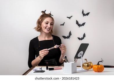 Young Woman Doing Halloween Makeup In Front Of The Mirror. Close Up Portrait. Halloween Makeup - Concept