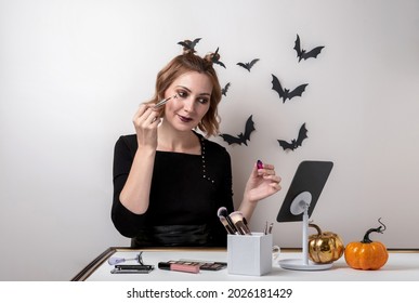 Young Woman Doing Halloween Makeup In Front Of The Mirror. Close Up Portrait. Halloween Makeup - Concept