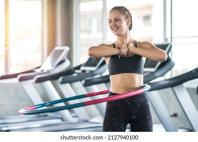 Young woman doing hula hoop during an exercise class in fitness gym. Healthy sports lifestyle, Fitness, Healthy concept.