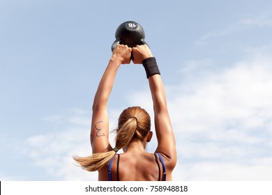 Young woman doing kettlebell swings at crossfit competition