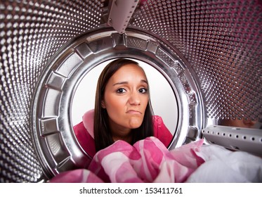 Young woman doing laundry View from the inside of washing machine. 