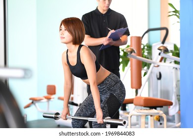 A young woman doing muscle training (deadlift) at the gym - Powered by Shutterstock