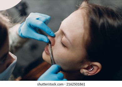 Young Woman Doing Piercing Nose Ring At Beauty Studio Salon