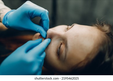 Young Woman Doing Piercing Nose Ring At Beauty Studio Salon