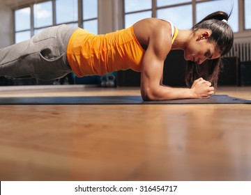 Young Woman Doing Pilates, Working On Abdominal Muscles. Muscular Female Doing Core Workout In The Gym.