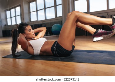 Young Woman Doing Pilates, Working On Abdominal Muscles. Fitness Woman Exercising To  Improve Core Muscle Strength In Gym.