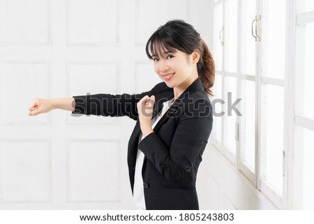 Young woman doing punching gesture shot in studio