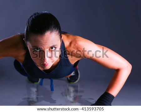 Similar – Close up front portrait of one young athletic woman in sportswear in gym over dark background, standing in boxing stance with hands and fists, looking at camera