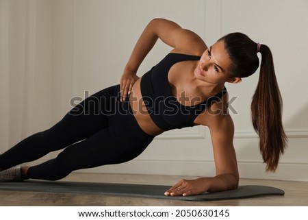 Similar – Image, Stock Photo Slim female doing side plank star pose during yoga session in park