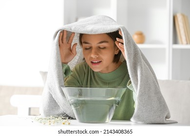 Young woman doing steam inhalation at home to soothe and open nasal passages - Shutterstock ID 2143408365