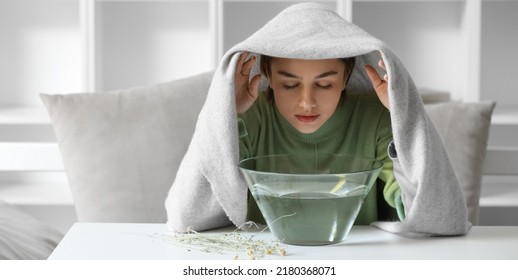 Young woman doing steam inhalation at home to soothe and open nasal passages - Shutterstock ID 2180368071
