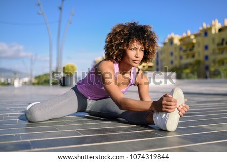 Similar – Young black woman doing stretching after running outdoors