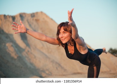 Young Woman Doing Warrior 3 Yoga Pose Outdoors