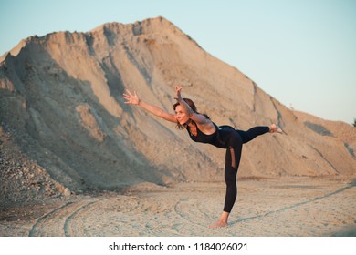 Young Woman Doing Warrior 3 Yoga Pose Outdoors