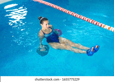 Young woman doing water aerobics in indoor pool, sporting concept