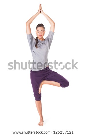 Young woman doing yoga exercise tree-pose isolated on white background
