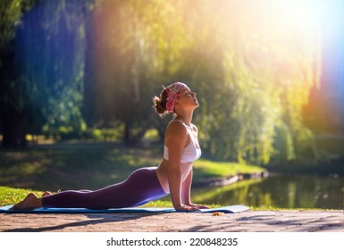 Young woman doing yoga in morning park  - Shutterstock ID 220848235