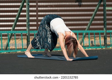 Young Woman Doing Yoga Outside On Court.