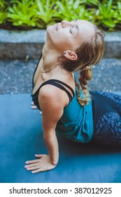 Young Woman Doing Yoga Outside In Natural Environment