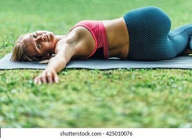 Young Woman Doing Yoga, Reclining Spinal Twist Position