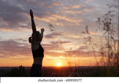 Young woman doing yoga in sunrise 