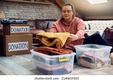 Young Woman Donating Her Clothes For Charity Organization.