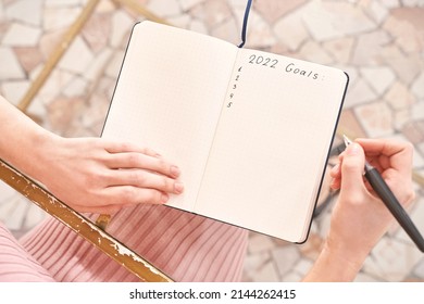 Young woman drawing goals indoors. Psychology treatment. Home vacation flatlay. Alone in interior. Happy emotion. Female person hands. Lifestyle action. Posing on table