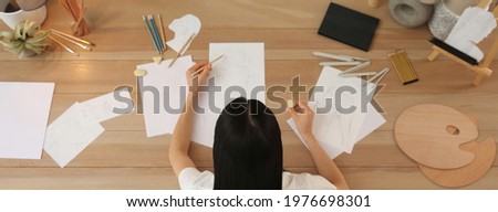 Young woman drawing male portrait at table indoors, above view. Banner design