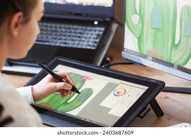 Young woman drawing on a digital tablet. Female graphic designer working from home. Girl drawing on a digital drawing board, view from behind - Powered by Shutterstock