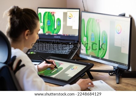 Young woman drawing on a digital tablet at home. Girl working from home as graphic designer.