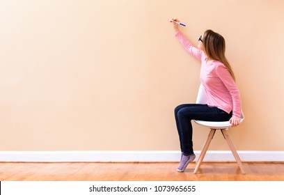 Young Woman Drawing Something On A Big Open Wall