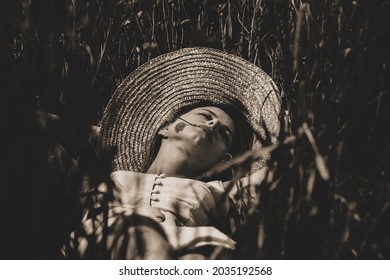 Young woman in dress lying down on a grass. Image in black and white color style