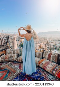 Young woman in dress on the roof with amazing view of Cappadocia in Turkey
