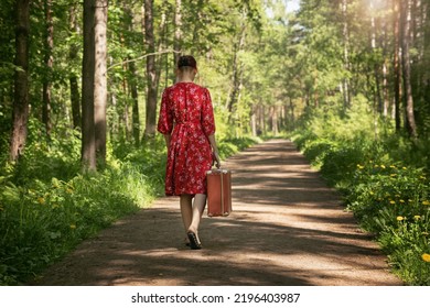 A Young Woman In A Dress With A Suitcase In Her Hand Walks Along The Road, Leaves Her Parents' House, Goes To Study, Starts An Independent Life,