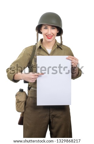young woman dressed in wwii military us uniform with helmet showing empty blank signboard with a copyspace