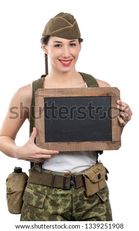 a young woman dressed in wwii military uniform with cap showing empty blank chalkboard with copy space