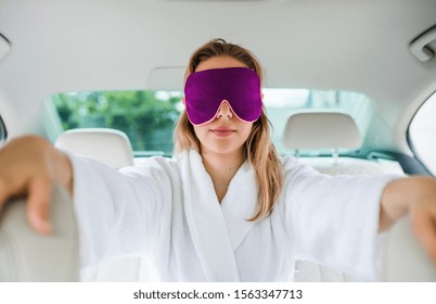 Young Woman With Dressing Gown And Eye Mas Sitting In Car, Resting.