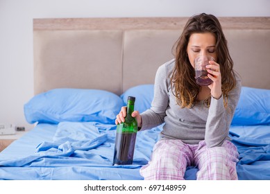 Young Woman Drinking Alcohol Depressed At Home