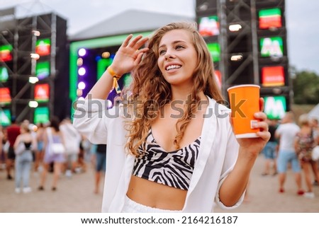 Young woman drinking beer and having fun at music festival.  Beach party, summer holiday, vacation concept.