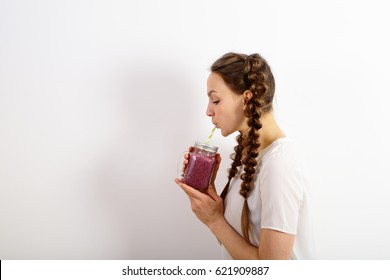 Young Woman Drinking Blueberry Smoothie