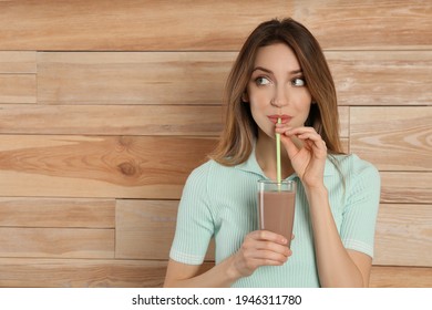 Young Woman Drinking Chocolate Milk On Wooden Background. Space For Text