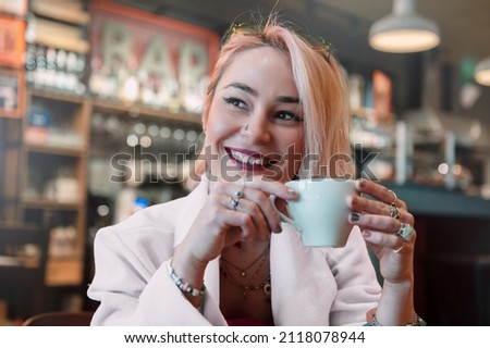 Young woman is drinking coffee in a cafe. 