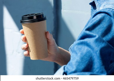 Young woman drinking coffee from disposable cup