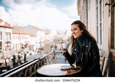 Young Woman Drinking Coffee On The Balcony.