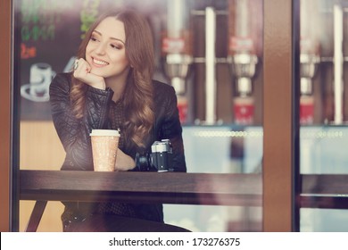 Young woman drinking coffee sitting indoor in urban cafe. Cafe city lifestyle. Casual portrait of teenager girl. Toned. - Powered by Shutterstock