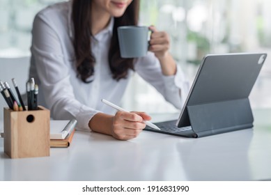 Young Woman Drinking Coffee And Using Tablet In The Office.