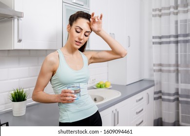 Young Woman Drinking And Dry Her Sweaty Forehead