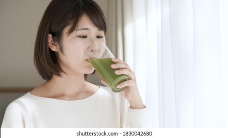 
Young Woman Drinking Green Juice